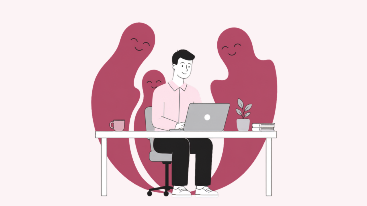 En person sidder ved et skrivebord med en bærbar computer, omgivet af tre smilende, venligt udseende spøgelseslignende figurer. På skrivebordet står der en kop, en plante og nogle bøger. Temaet er lyst og positivt.