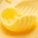 Foto af smør eller margarine rullet som en krølle.