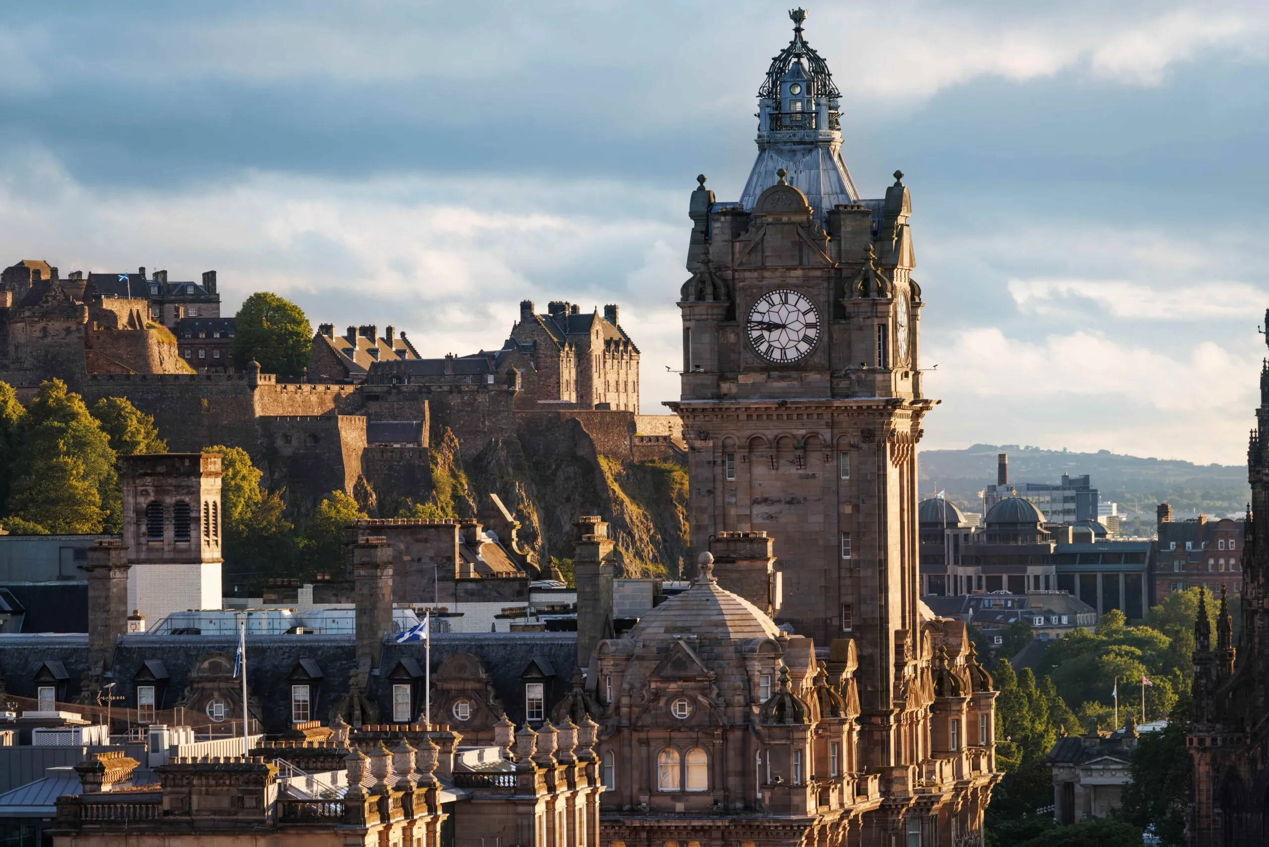Urtårnet på Balmoral Hotel i Edinburgh med Edinburgh Castle synligt på bakken i baggrunden.