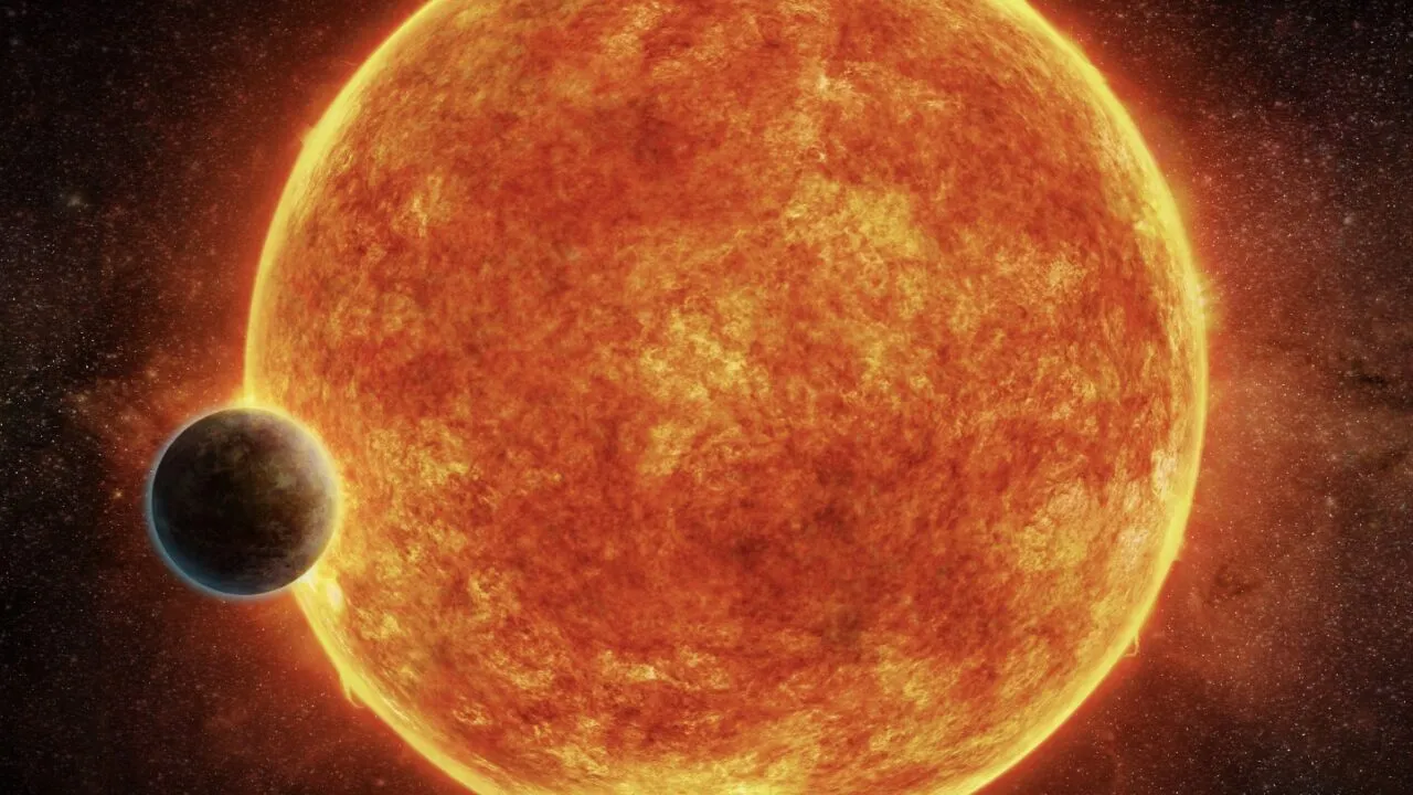 En stor, lys, orange sol med en mindre, klippefyldt planet i forgrunden.